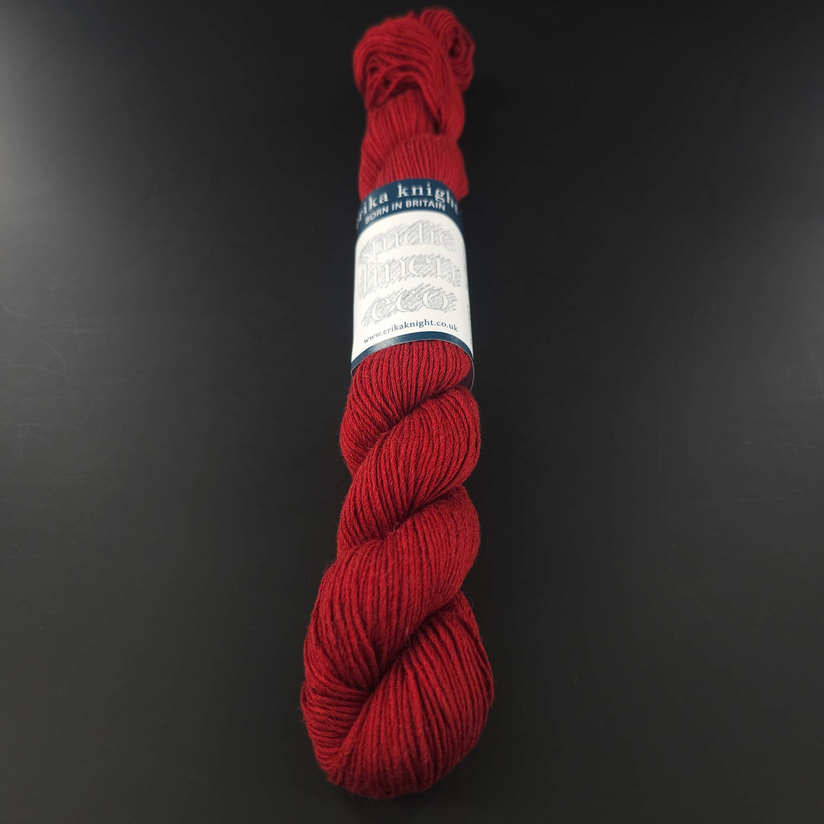 Echeveau de lin Studio Linen Eco d'Erika Knight de couleur 421 Lighthouse (rouge) sur fond noir pour tricot et crochet.
