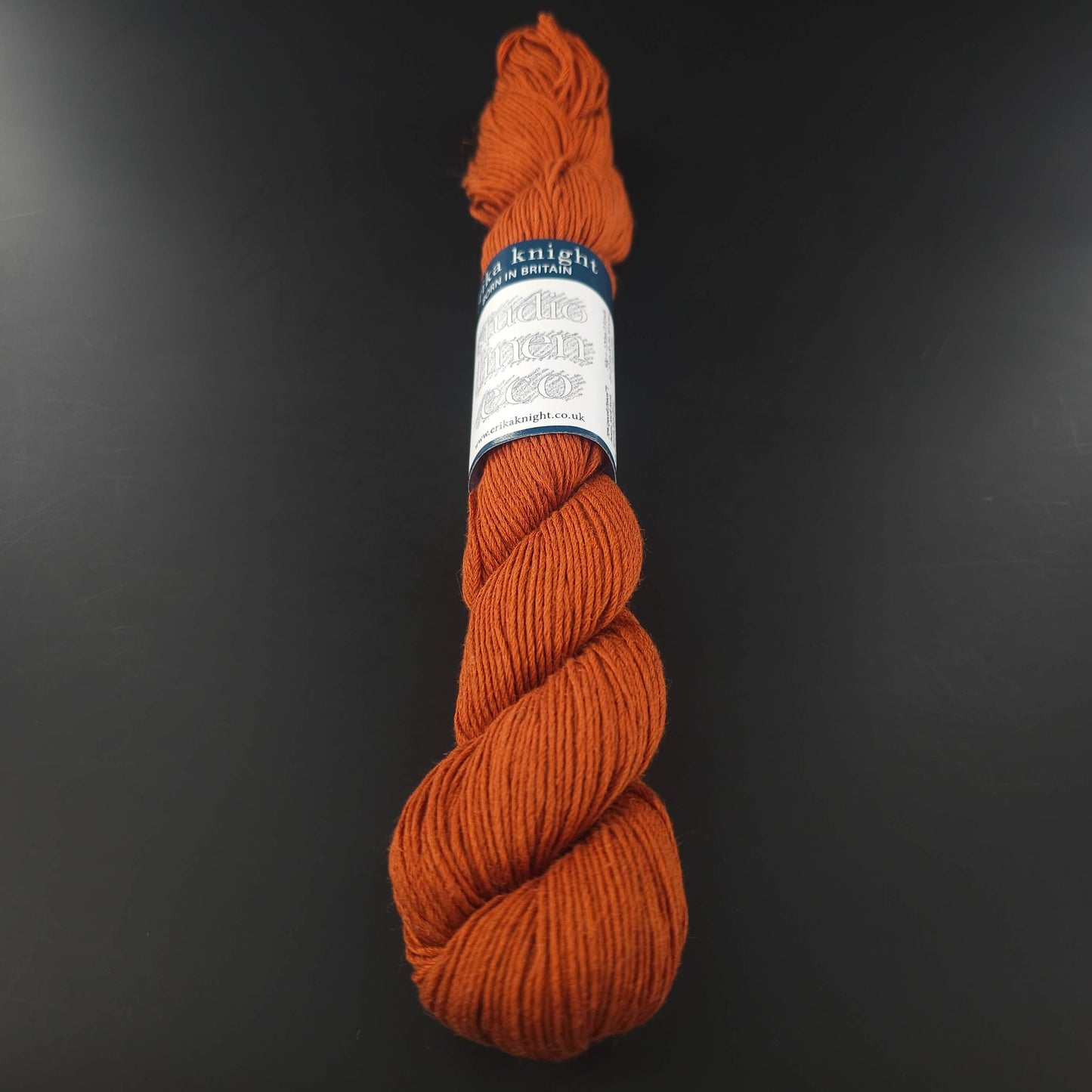 Echeveau de lin Studio Linen Eco d'Erika Knight de couleur 422 Brick (rouille) sur fond noir pour tricot et crochet.