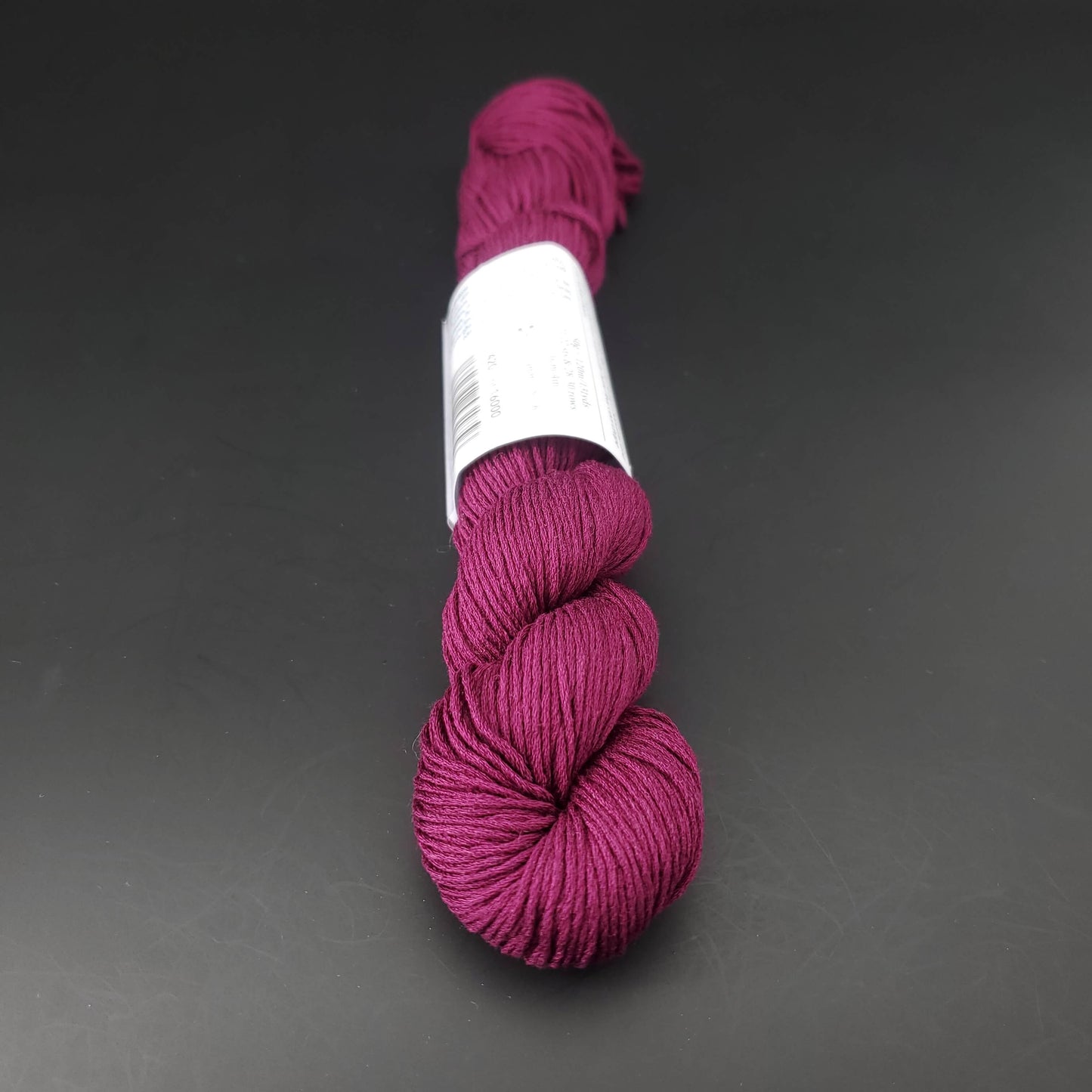 Echeveau de lin Studio Linen d'Erika Knight de couleur 420 pomegranate sur fond noir pour tricot et crochet.
