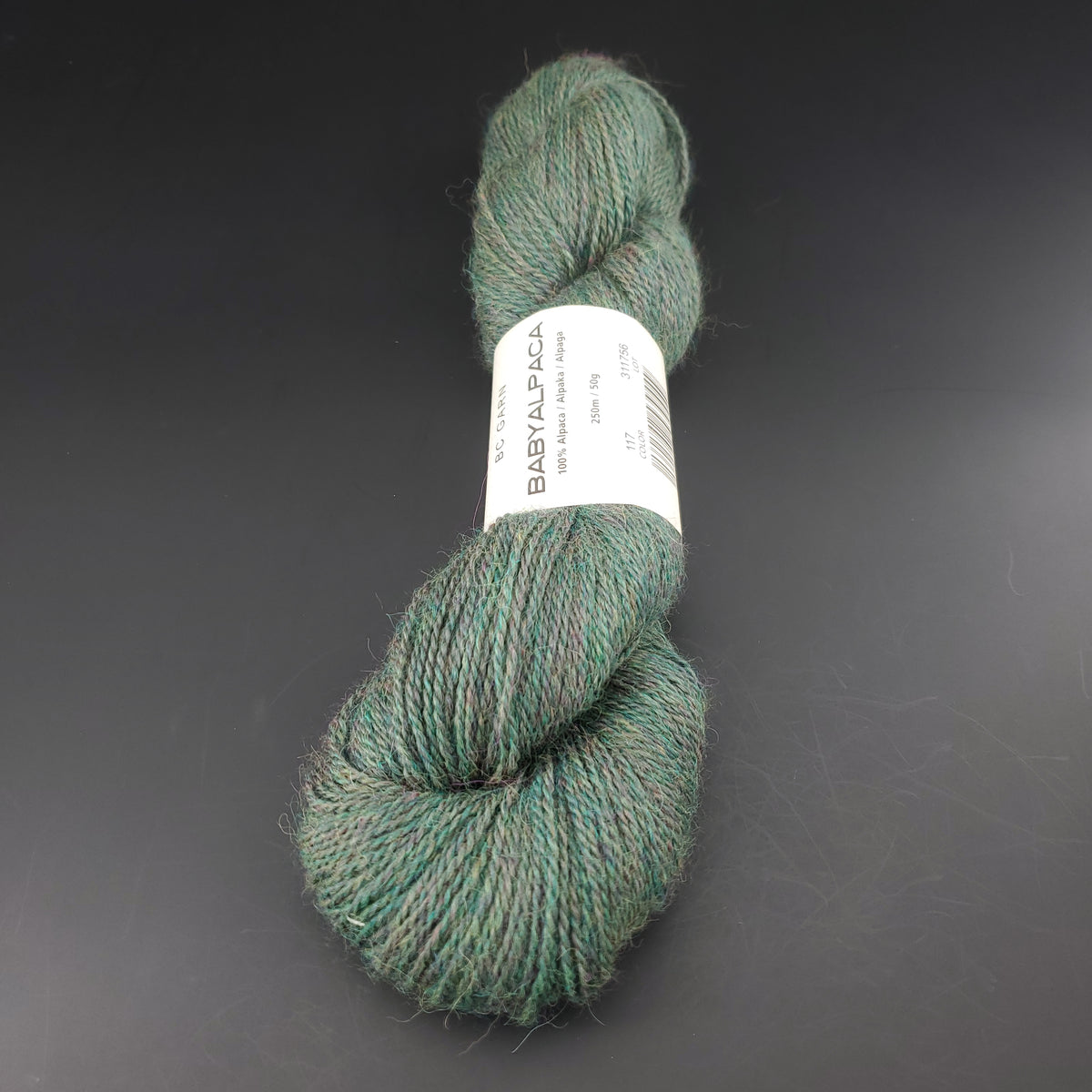 Echeveau de laine Baby Alpaca de BC Garn de couleur 117 woods heather sur fond noir.