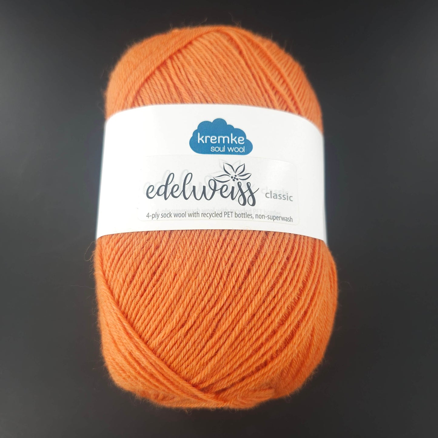pelote de laine edelweiss classic de marque kremke de coloris 408 orange chaud pour tricot et crochet sur fond noir