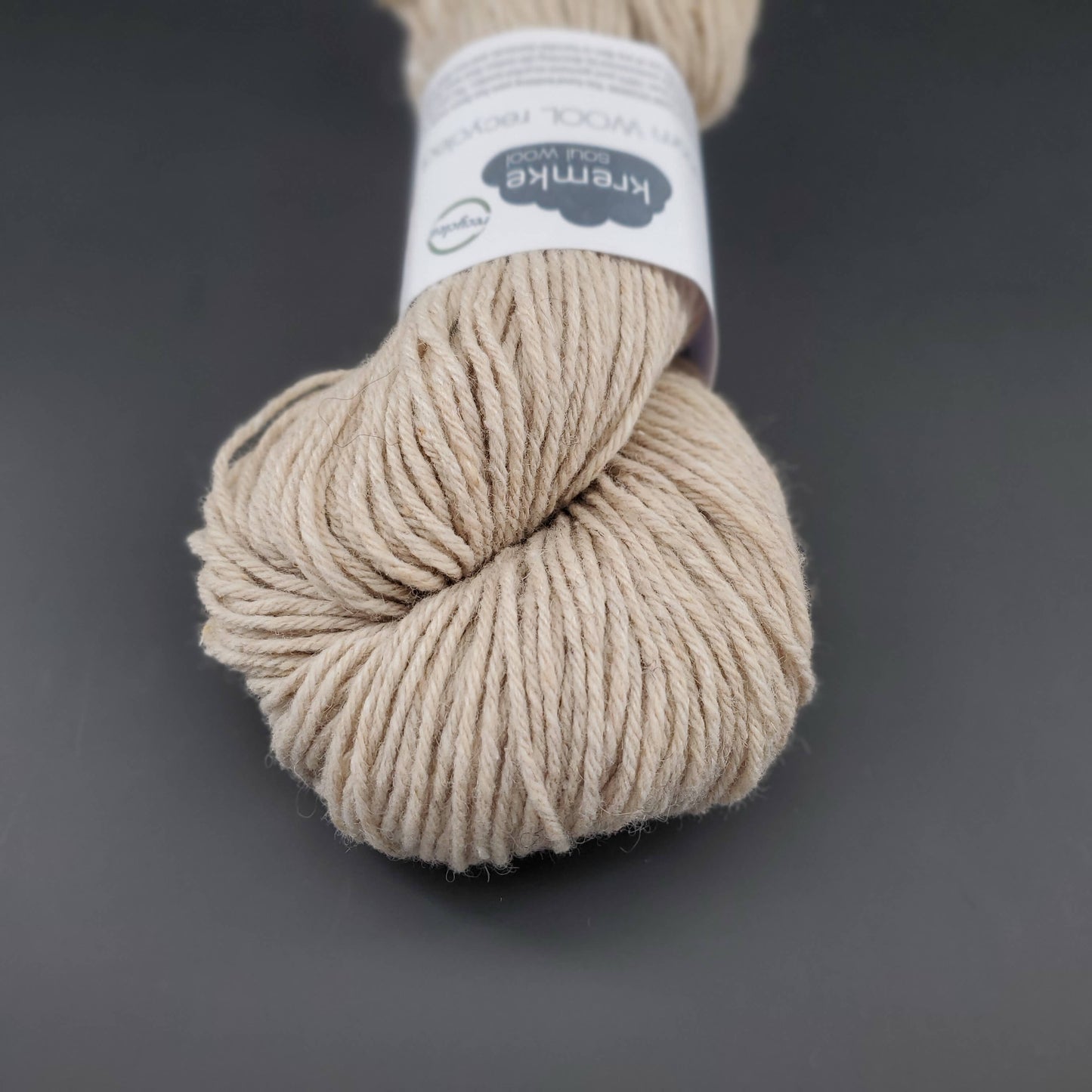 Echeveau de laine Kremke Reborn Wool de couleur 02 (pearl), sur fond noir, pour tricot et crochet.