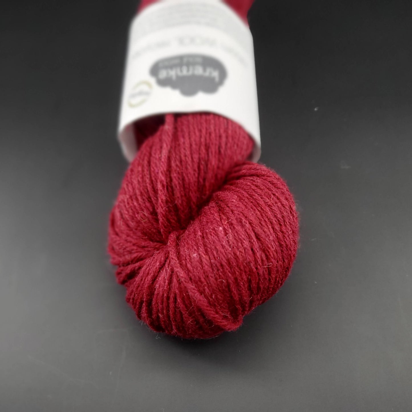 Echeveau de laine Kremke Reborn Wool de couleur 10 wine, sur fond noir, pour tricot et crochet.