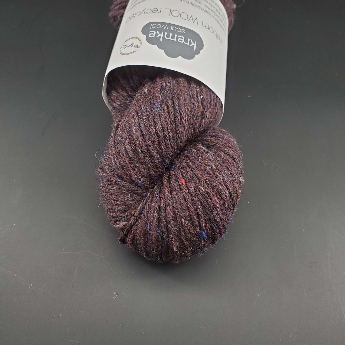 Echeveau de laine Kremke Reborn Wool de couleur 16 coffee melange, sur fond noir, pour tricot et crochet.