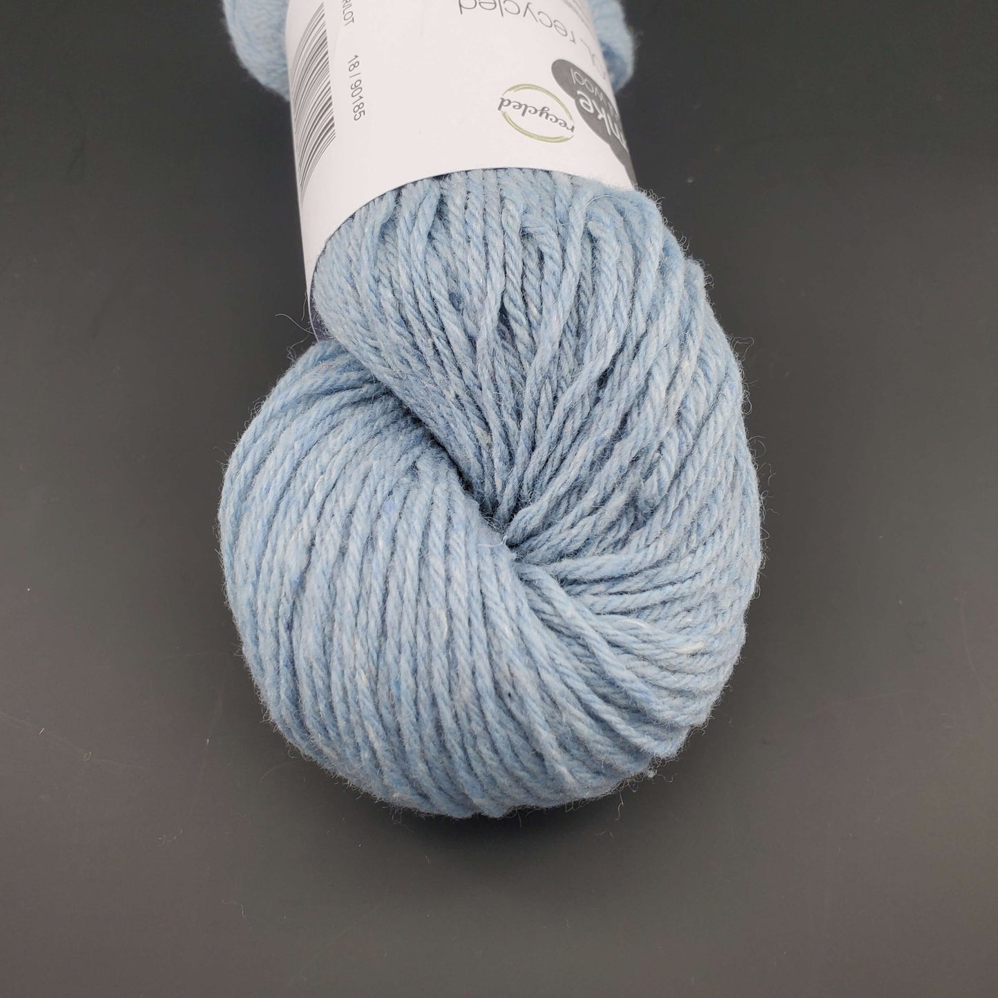 Echeveau de laine Kremke Reborn Wool de couleur 18 pastel blue, sur fond noir, pour tricot et crochet.