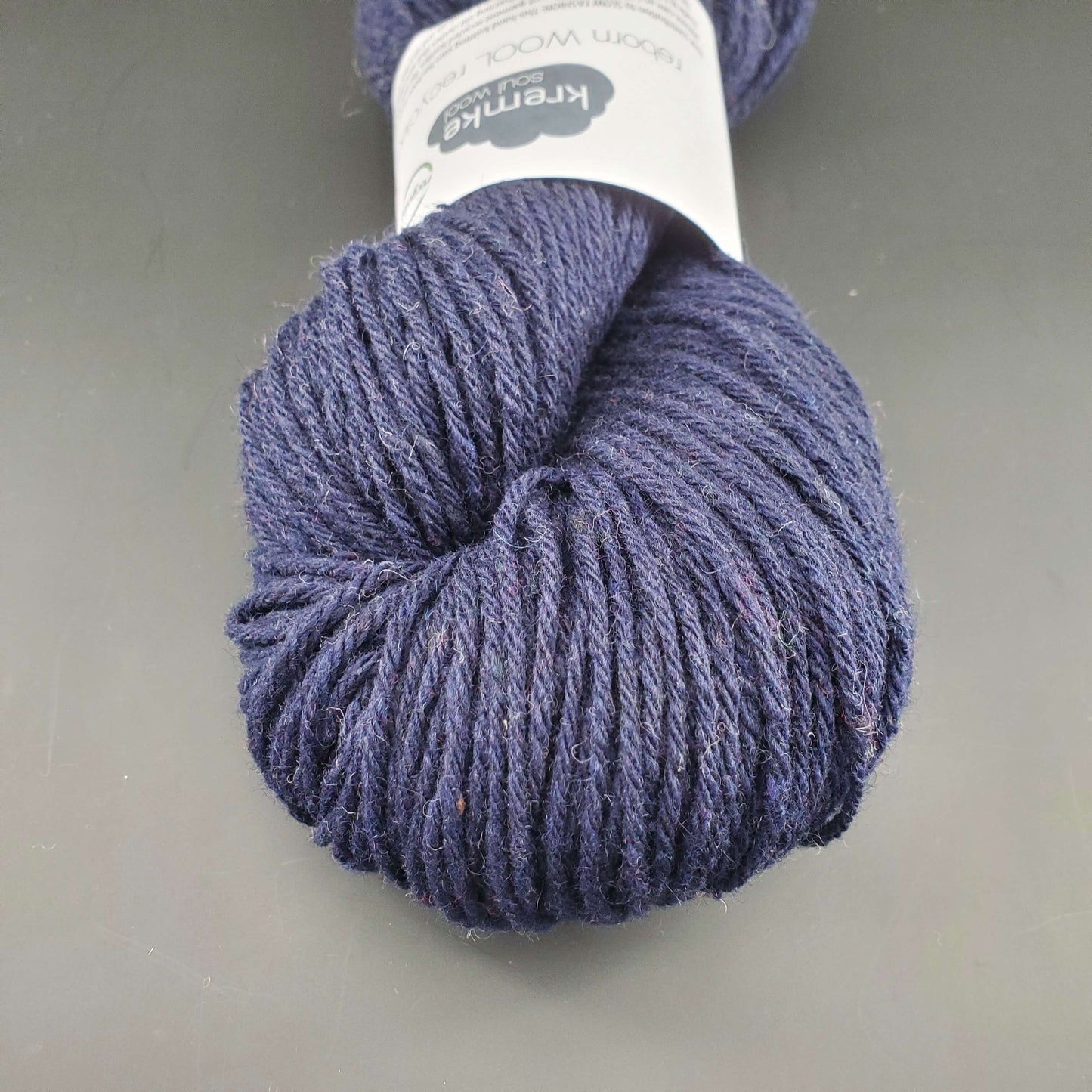 Echeveau de laine Kremke Reborn Wool de couleur 21 navy blue, sur fond noir, pour tricot et crochet.