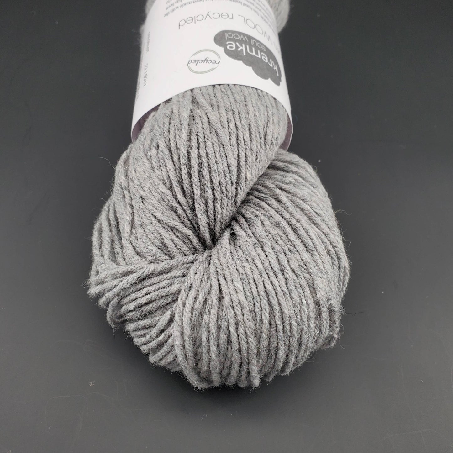 Echeveau de laine Kremke Reborn Wool de couleur 22 light grey, sur fond noir, pour tricot et crochet.