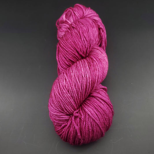 Echeveau de laine Malabrigo Arroyo de couleur 148 hollyhock sur fond noir pour tricot et crochet