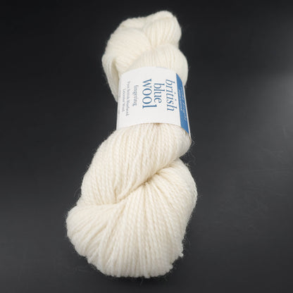écheveau de laine british blue fingering d'erika knight coloris 01 natural undyed sur fond noir pour tricot et crochet