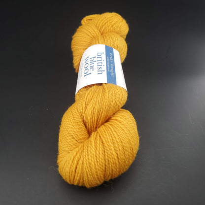 écheveau de laine british blue fingering d'erika knight coloris 04 mustard sur fond noir pour tricot et crochet