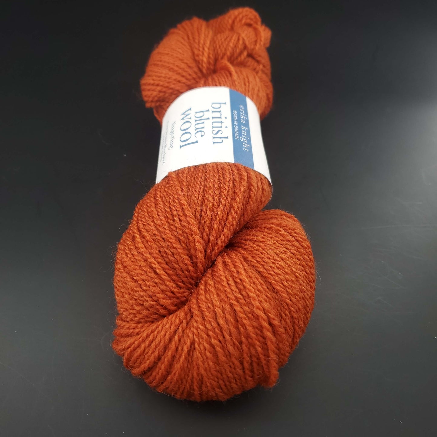 écheveau de laine british blue fingering d'erika knight coloris 05 burnt orange sur fond noir pour tricot et crochet