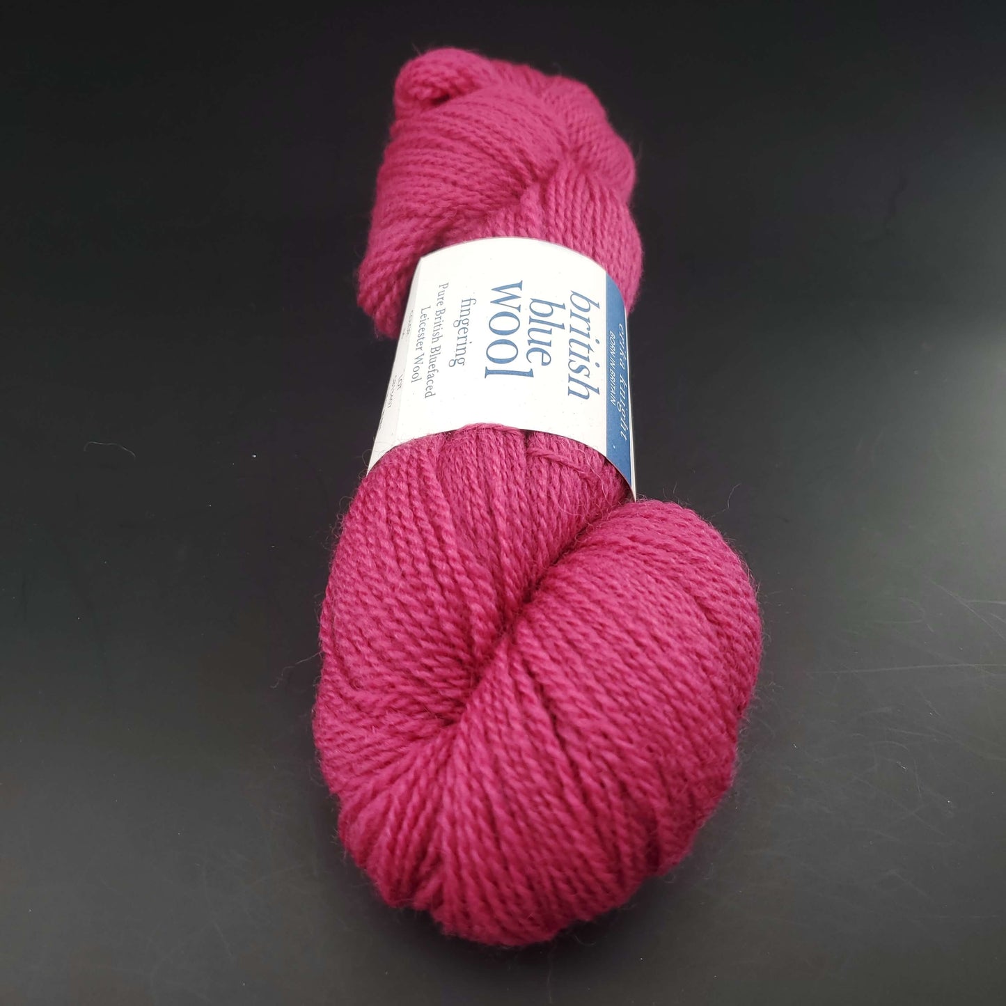 écheveau de laine british blue fingering d'erika knight coloris 06 cyclamen sur fond noir pour tricot et crochet