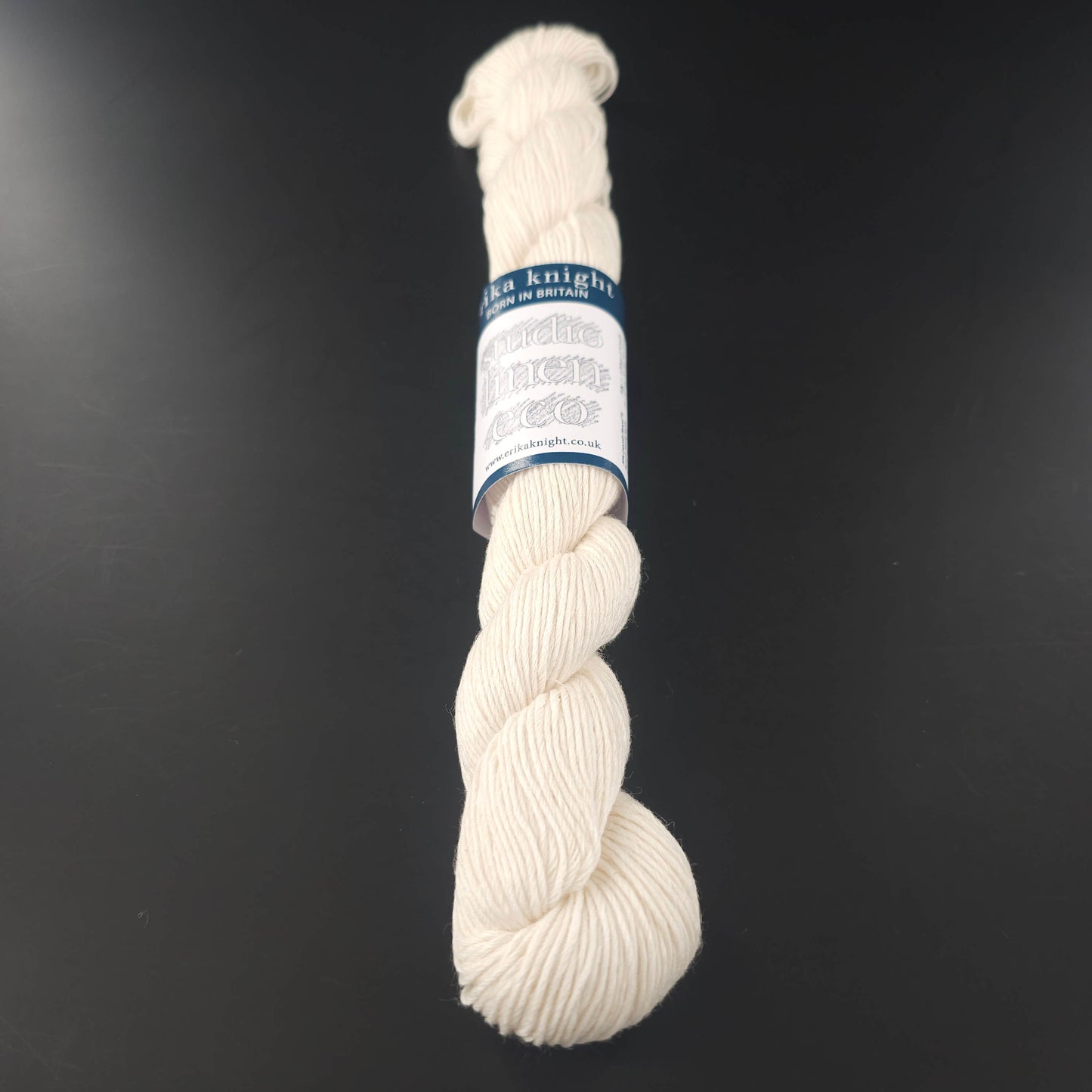 Echeveau de lin Studio Linen Eco d'Erika Knight de couleur 400 Milk (blanc) sur fond noir pour tricot et crochet.