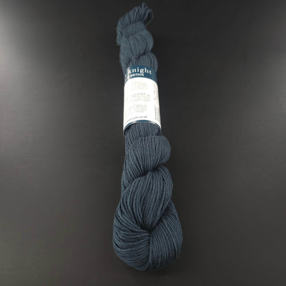 Echeveau de lin Studio Linen Eco d'Erika Knight de couleur 404 Neo (bleu pétrole) sur fond noir pour tricot et crochet.