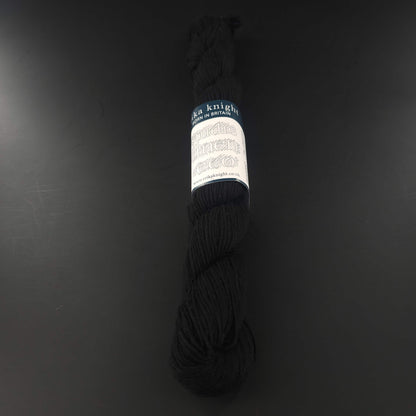 Echeveau de lin Studio Linen Eco d'Erika Knight de couleur 411 Kumo (noir) sur fond noir pour tricot et crochet.