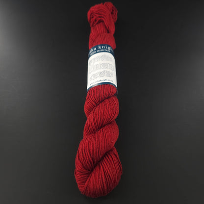 Echeveau de lin Studio Linen Eco d'Erika Knight de couleur 421 Lighthouse (rouge) sur fond noir pour tricot et crochet.