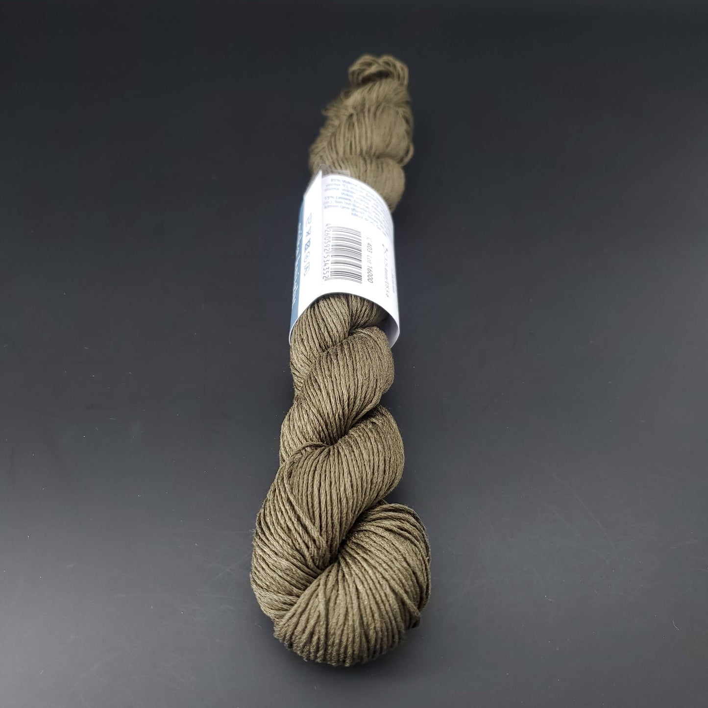 Echeveau de lin Studio Linen d'Erika Knight de couleur 403 fatigue sur fond noir pour tricot et crochet.
