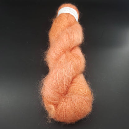 echeveau de fil fluffy mohair de marque cowgirlblues de coloris 42 carrot juice sur fond noir pour tricot et crochet