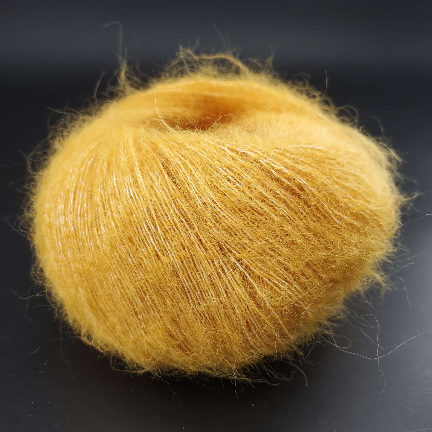 pelote de babysilk lace uni de marque kremke de coloris 1004 gold pour tricot et crochet sur fond noir