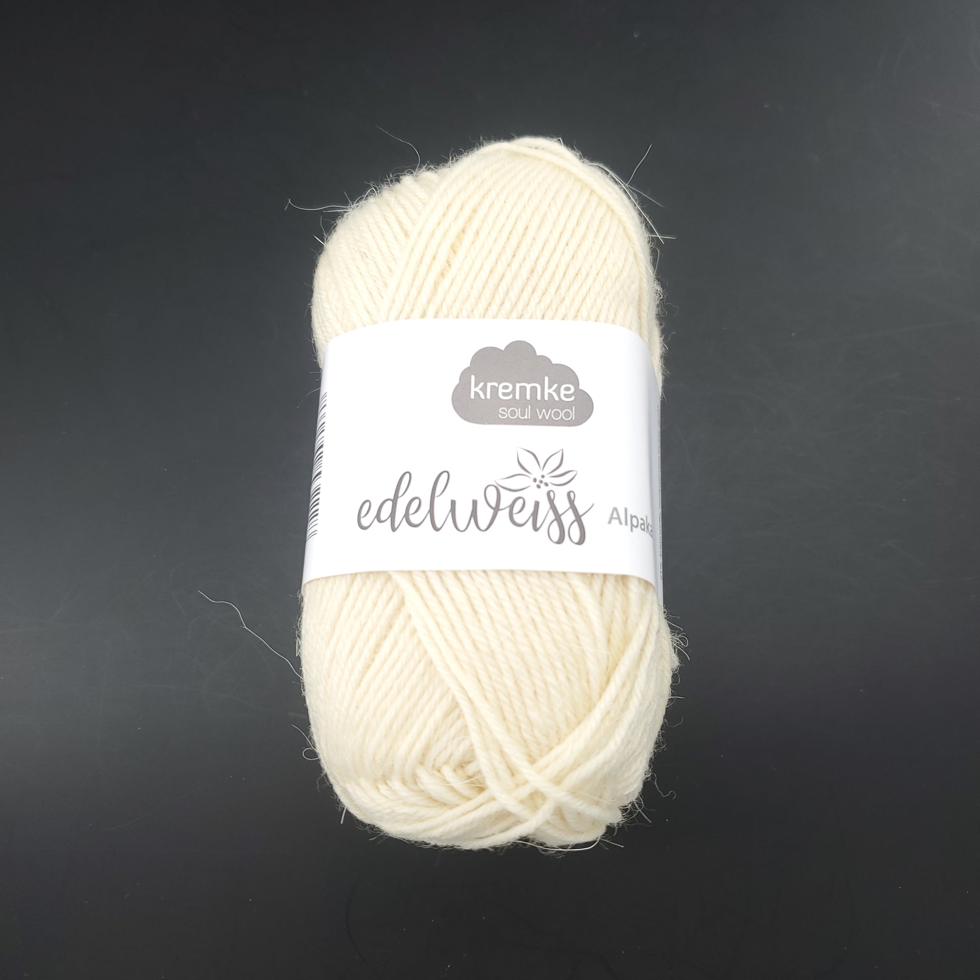 pelote de laine à chaussettes edelweiss alpaka 4ply de marque kremke de couleur 001 pour tricot et crochet sur fond noir