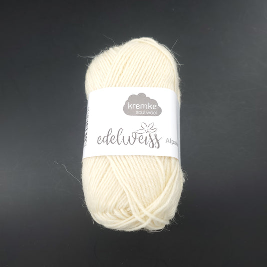 pelote de laine à chaussettes edelweiss alpaka 4ply de marque kremke de couleur 001 pour tricot et crochet sur fond noir
