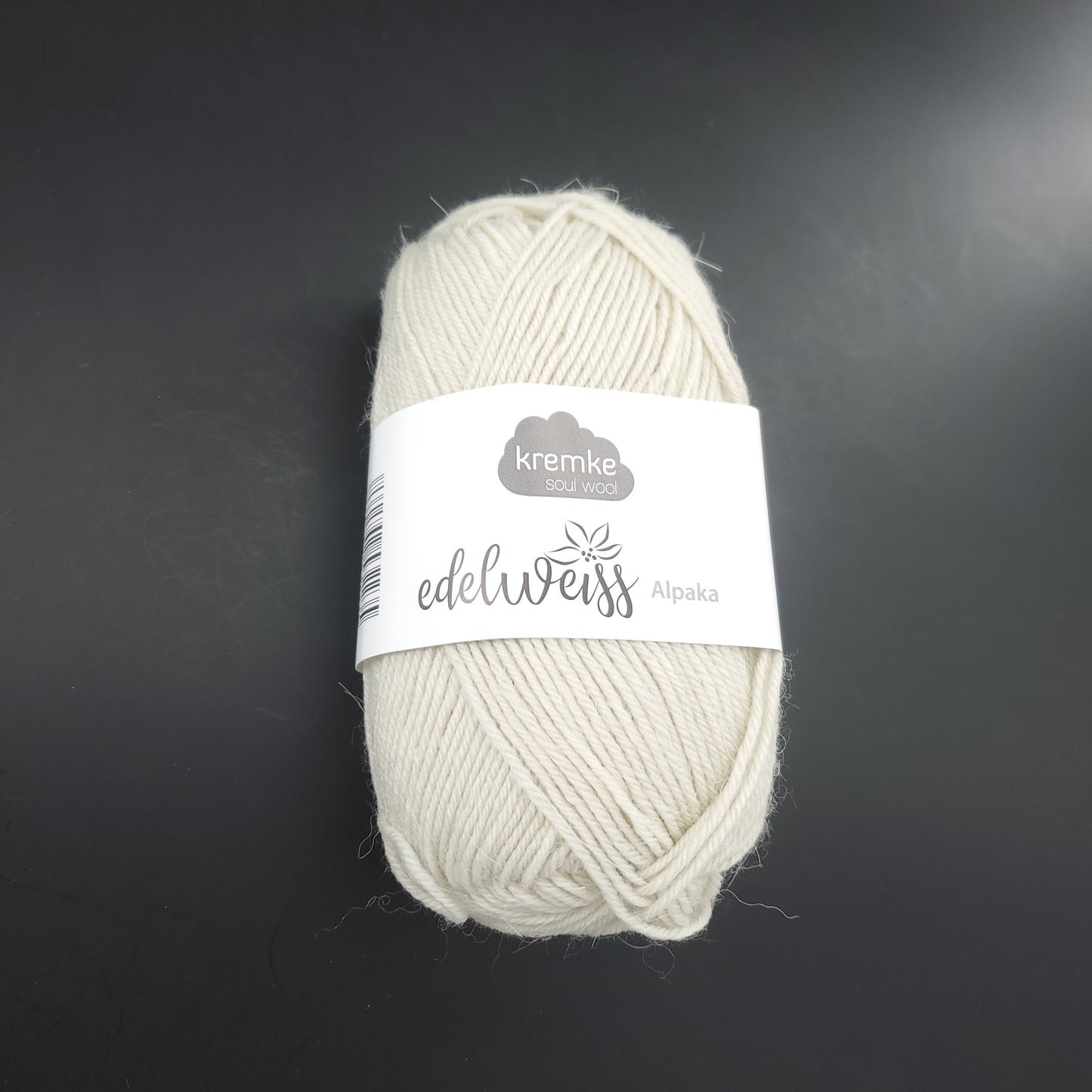 pelote de laine à chaussettes edelweiss alpaka 4ply de marque kremke de couleur 002 pour tricot et crochet sur fond noir