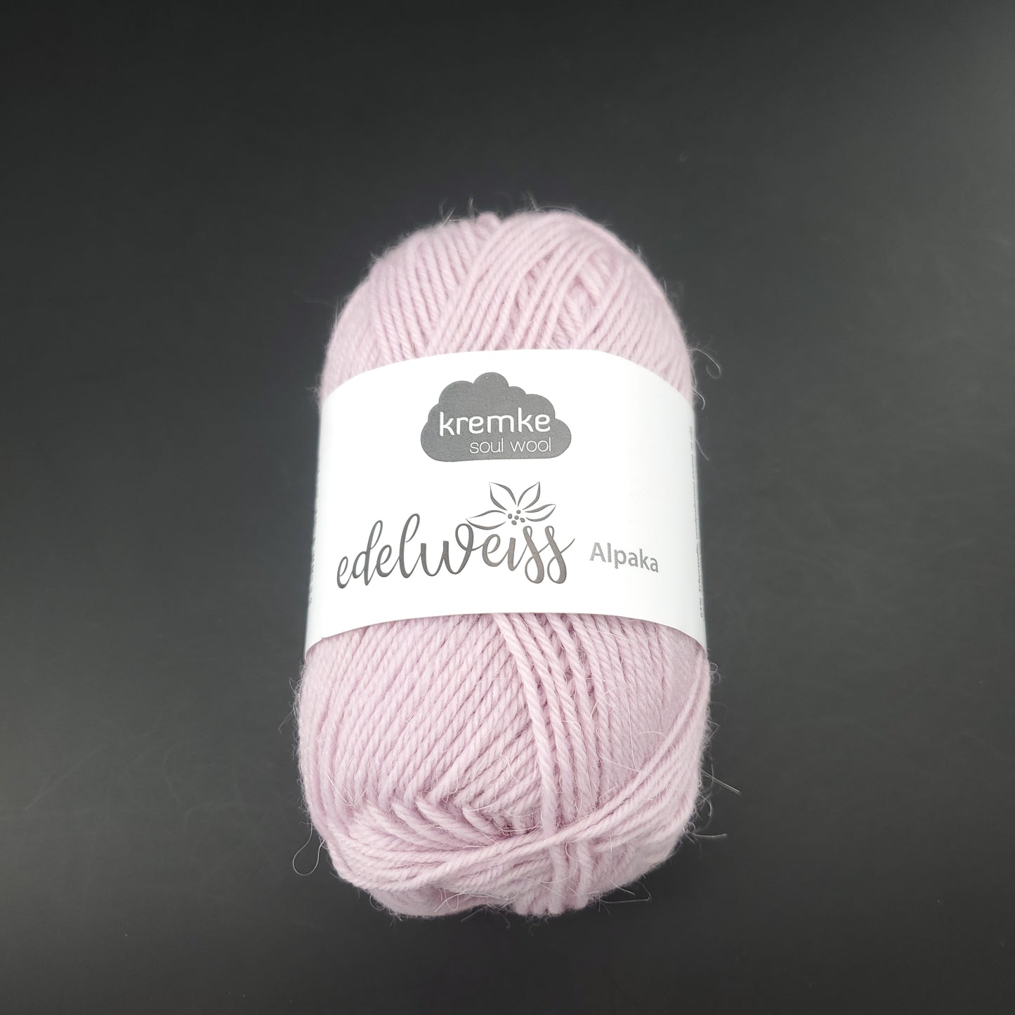 pelote de laine à chaussettes edelweiss alpaka 4ply de marque kremke de couleur 005 pour tricot et crochet sur fond noir