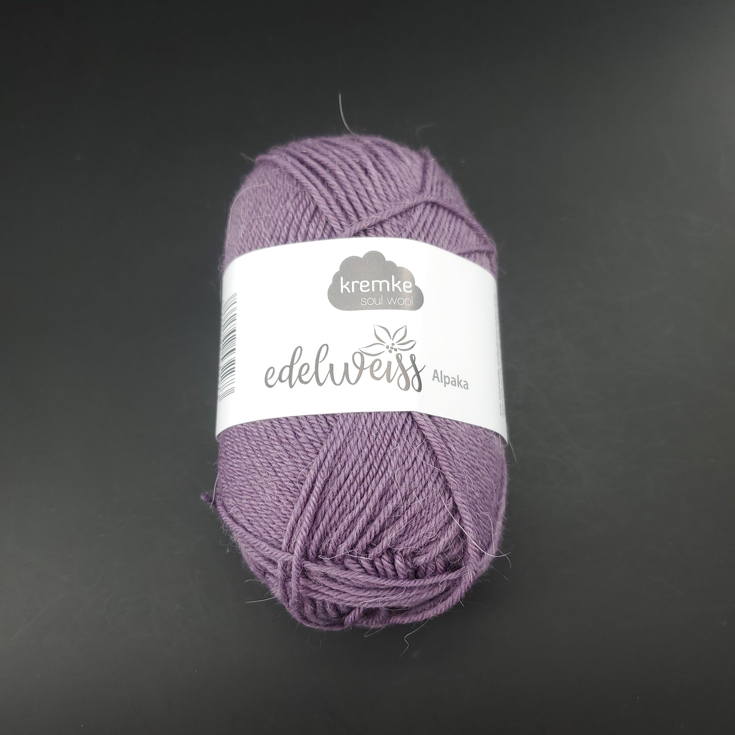 pelote de laine à chaussettes edelweiss alpaka 4ply de marque kremke de couleur 006 pour tricot et crochet sur fond noir