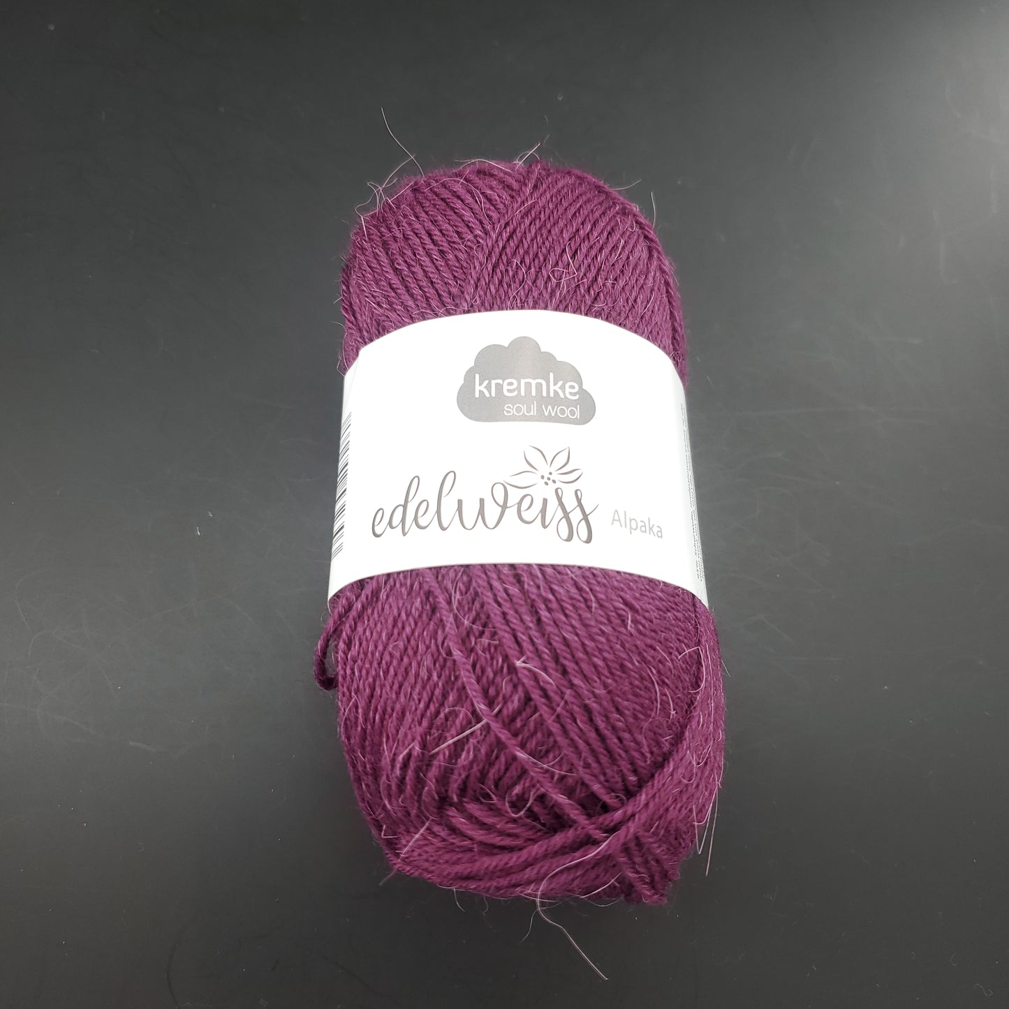 pelote de laine à chaussettes edelweiss alpaka 4ply de marque kremke de couleur 009 pour tricot et crochet sur fond noir