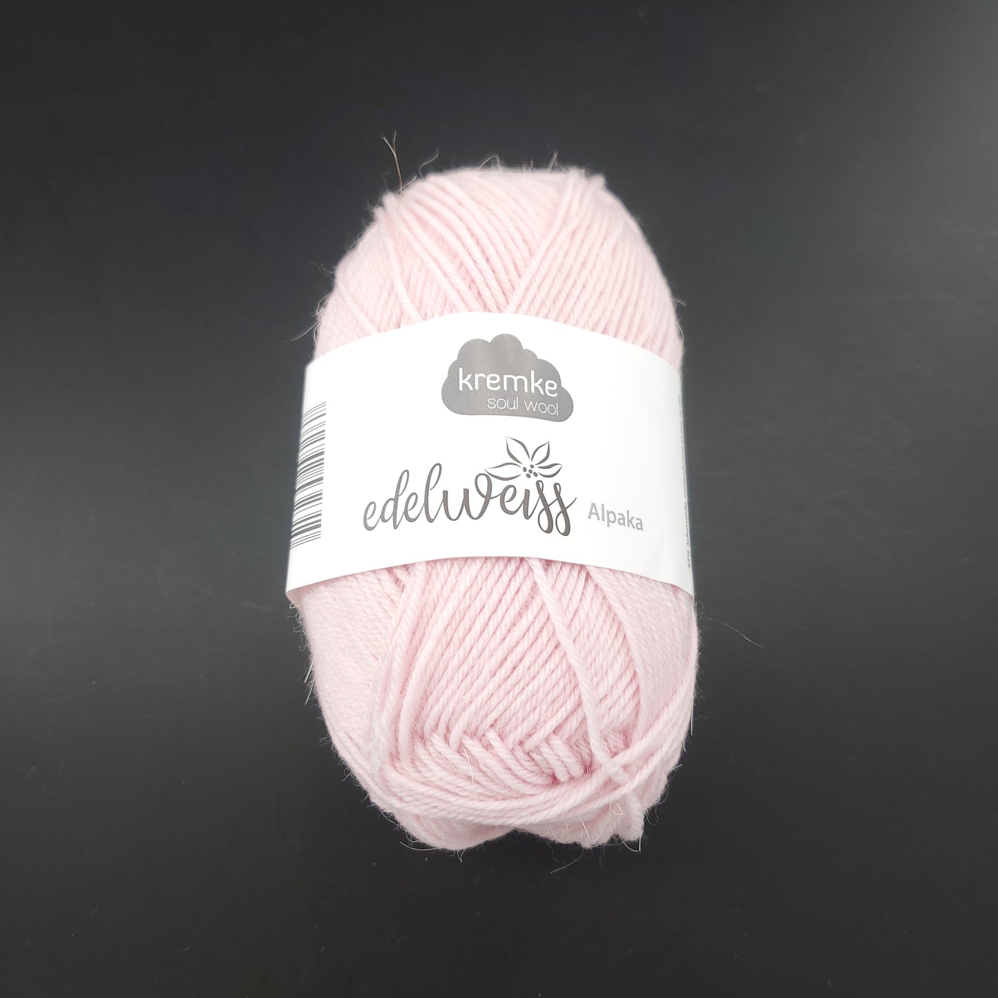 pelote de laine à chaussettes edelweiss alpaka 4ply de marque kremke de couleur 010 pour tricot et crochet sur fond noir
