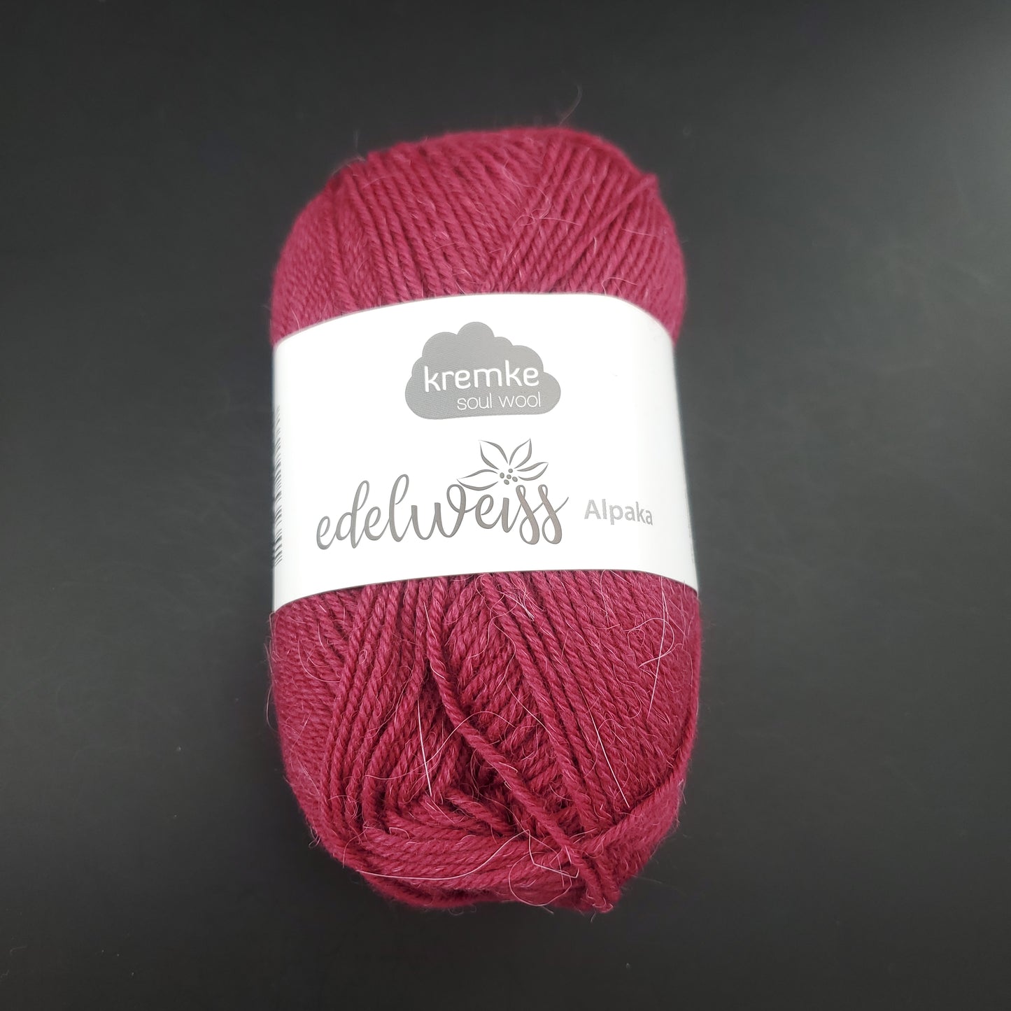 pelote de laine à chaussettes edelweiss alpaka 4ply de marque kremke de couleur 014 pour tricot et crochet sur fond noir