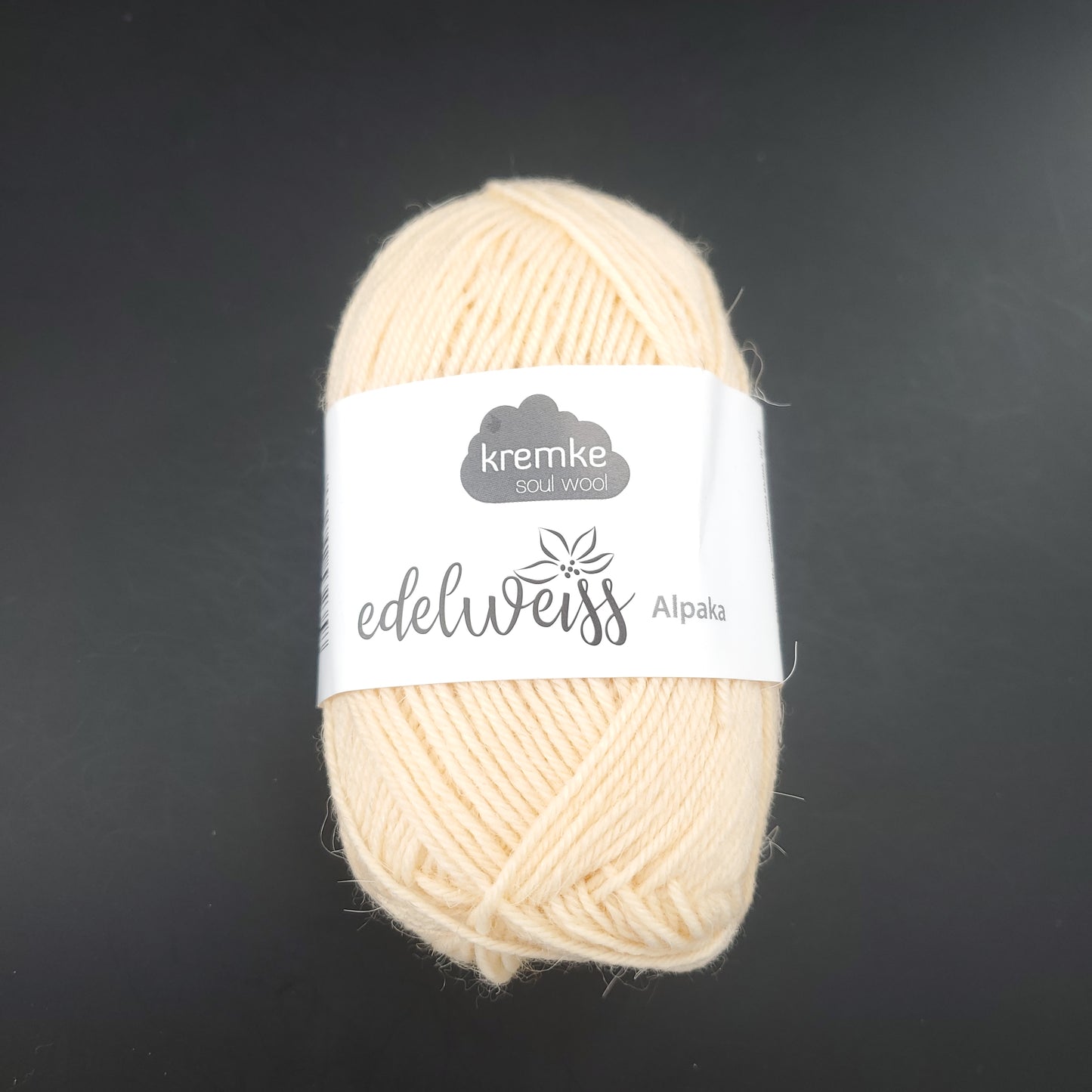 pelote de laine à chaussettes edelweiss alpaka 4ply de marque kremke de couleur 015 pour tricot et crochet sur fond noir