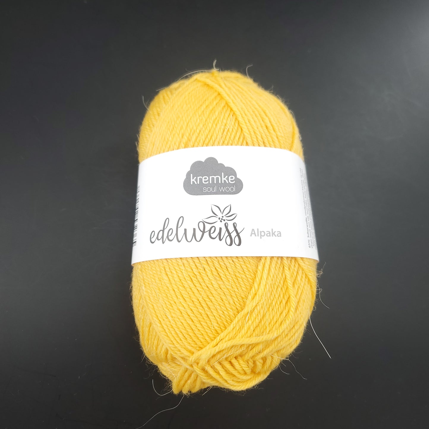 pelote de laine à chaussettes edelweiss alpaka 4ply de marque kremke de couleur 016 pour tricot et crochet sur fond noir