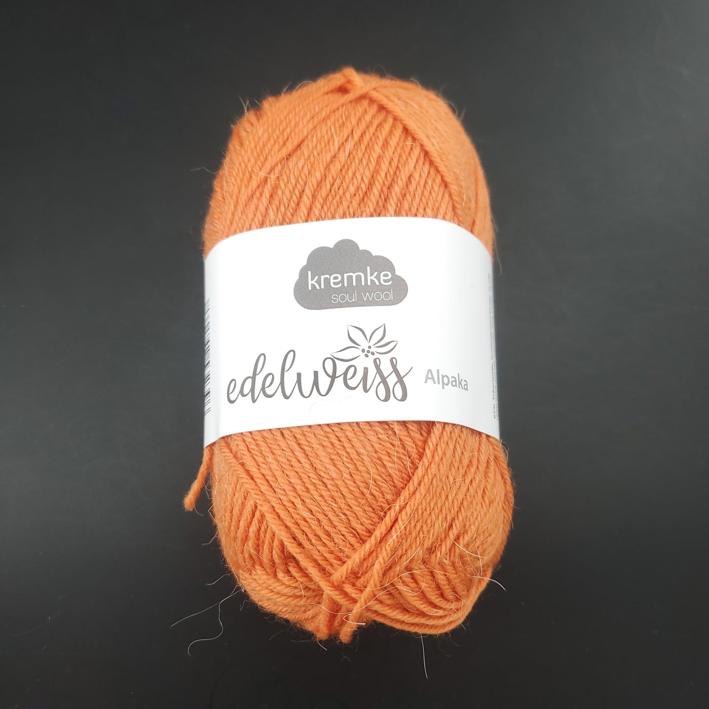 pelote de laine à chaussettes edelweiss alpaka 4ply de marque kremke de couleur 019 pour tricot et crochet sur fond noir