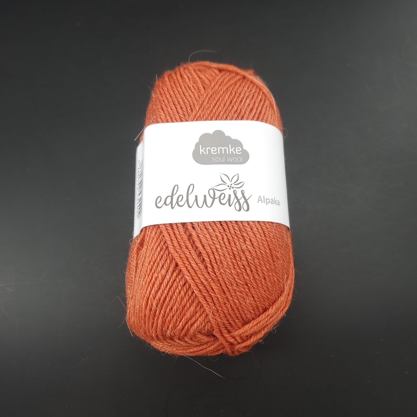 pelote de laine à chaussettes edelweiss alpaka 4ply de marque kremke de couleur 020 pour tricot et crochet sur fond noir
