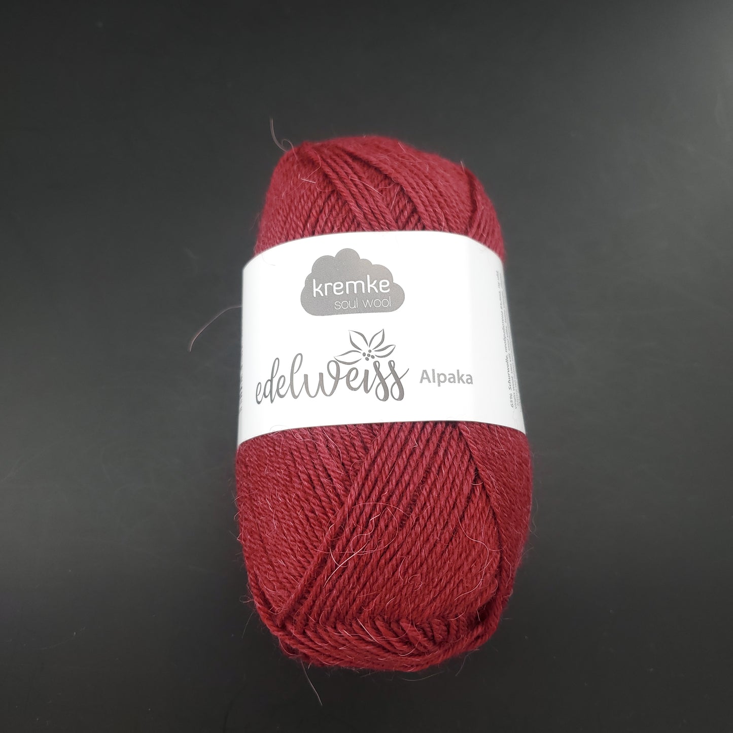 pelote de laine à chaussettes edelweiss alpaka 4ply de marque kremke de couleur 022 pour tricot et crochet sur fond noir