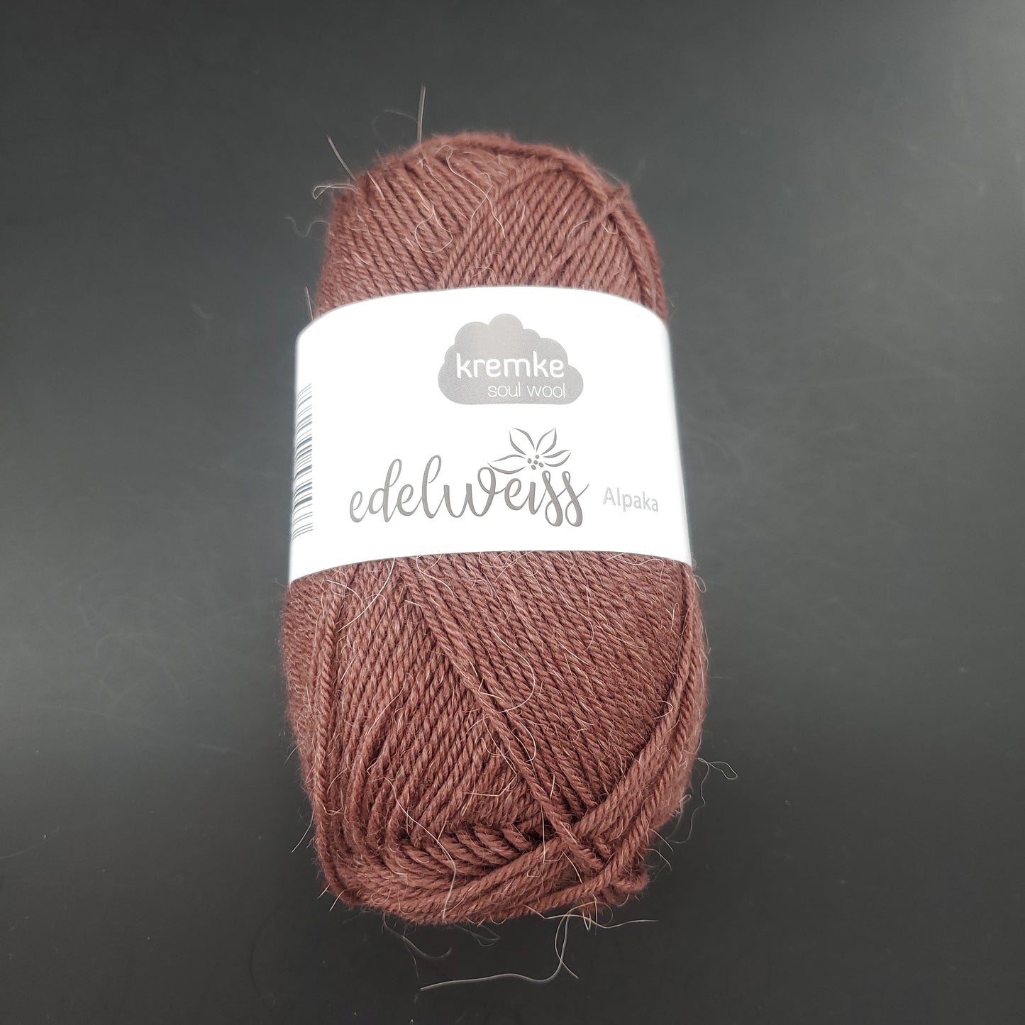 pelote de laine à chaussettes edelweiss alpaka 4ply de marque kremke de couleur 023 pour tricot et crochet sur fond noir