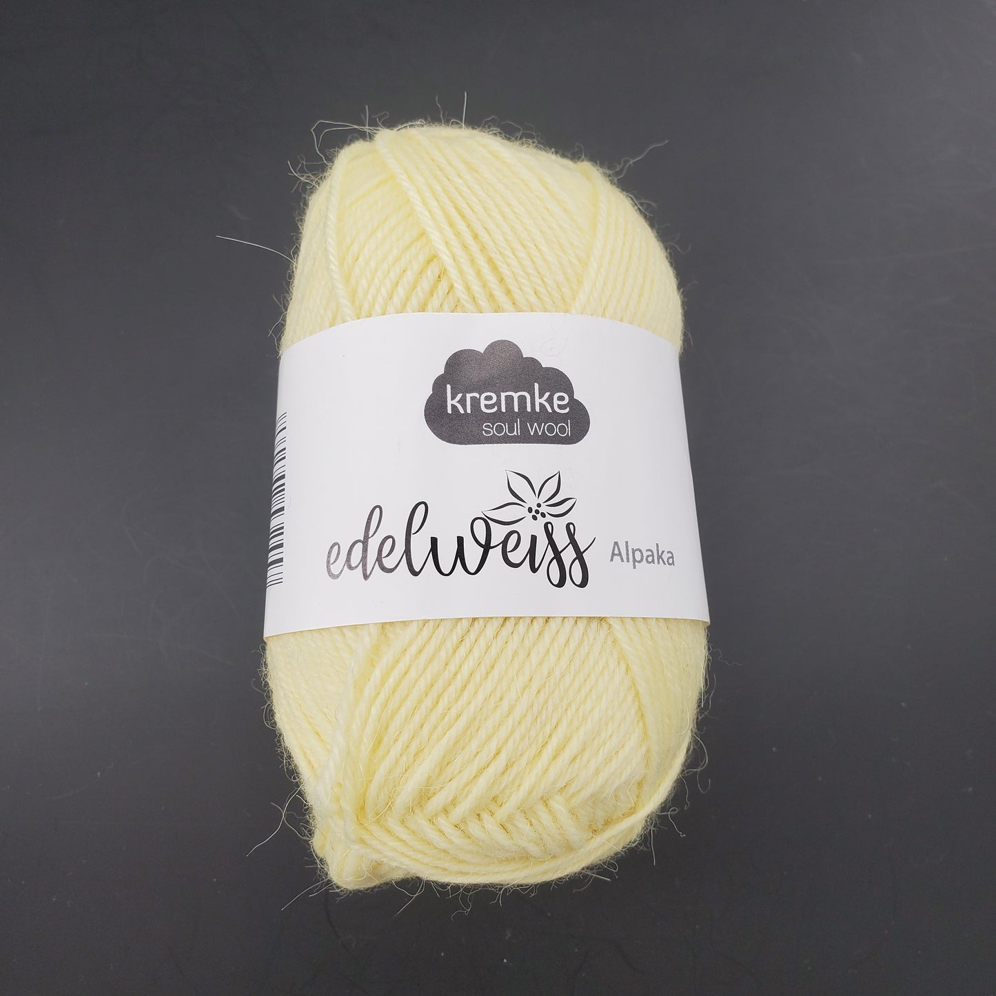 pelote de laine à chaussettes edelweiss alpaka 4ply de marque kremke de couleur 025 pour tricot et crochet sur fond noir