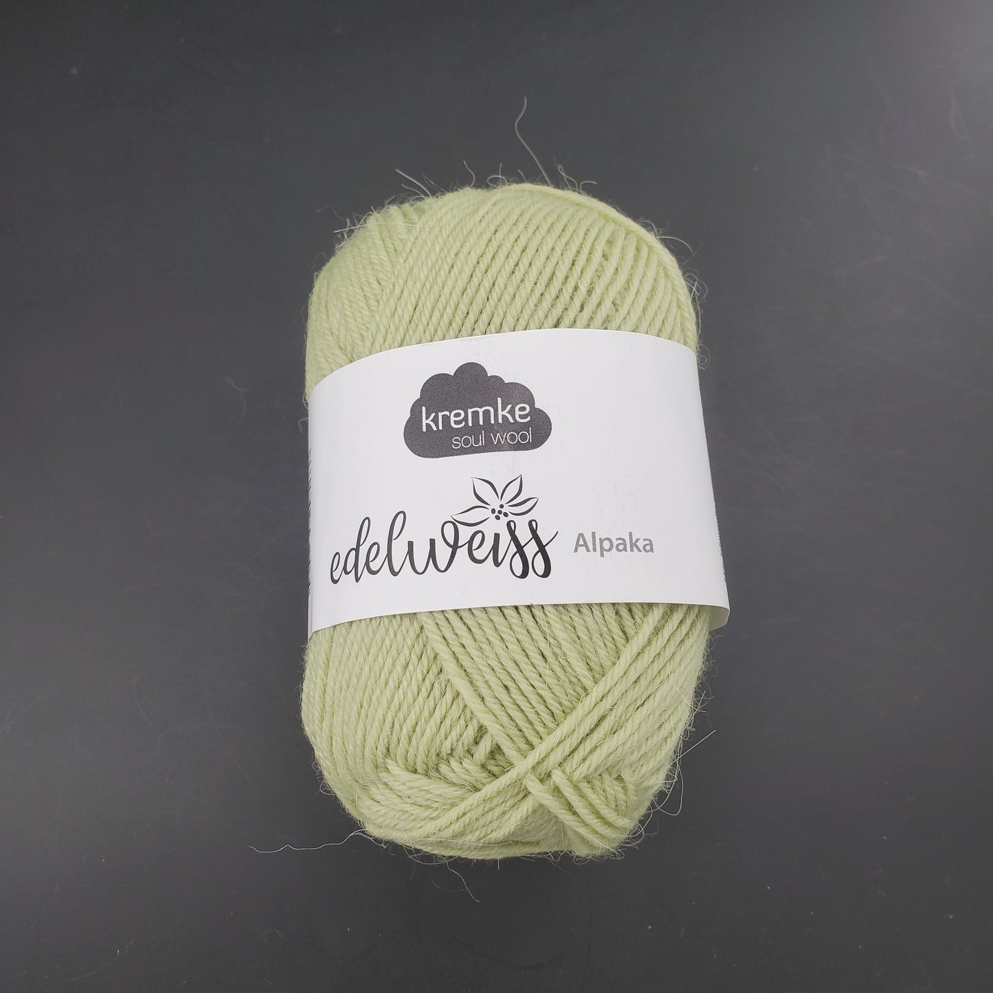 pelote de laine à chaussettes edelweiss alpaka 4ply de marque kremke de couleur 026 pour tricot et crochet sur fond noir