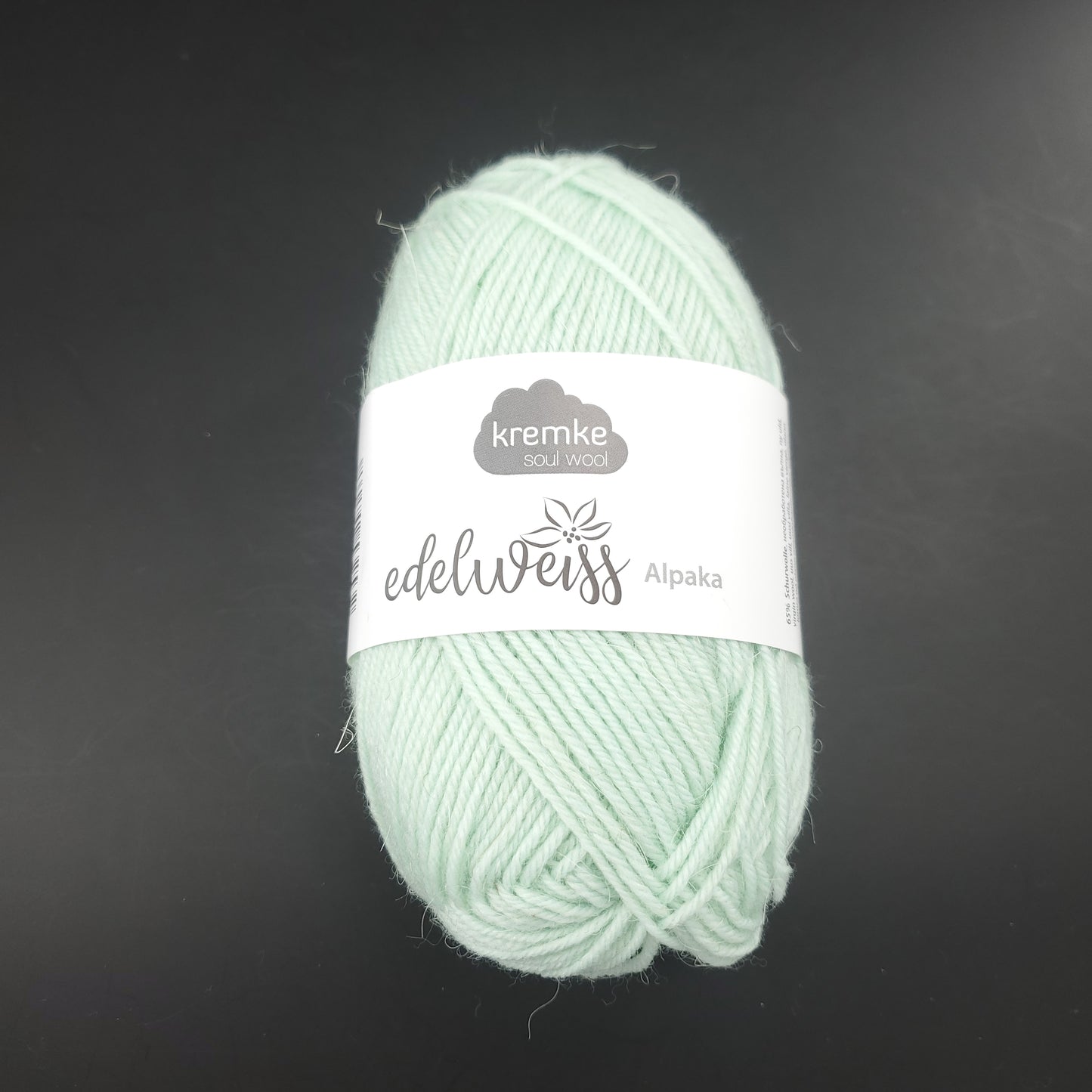 pelote de laine à chaussettes edelweiss alpaka 4ply de marque kremke de couleur 033 pour tricot et crochet sur fond noir