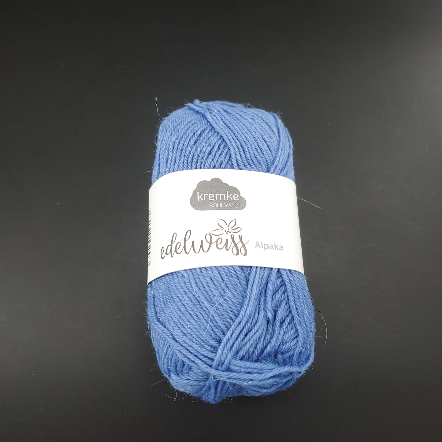 pelote de laine à chaussettes edelweiss alpaka 4ply de marque kremke de couleur 038 pour tricot et crochet sur fond noir