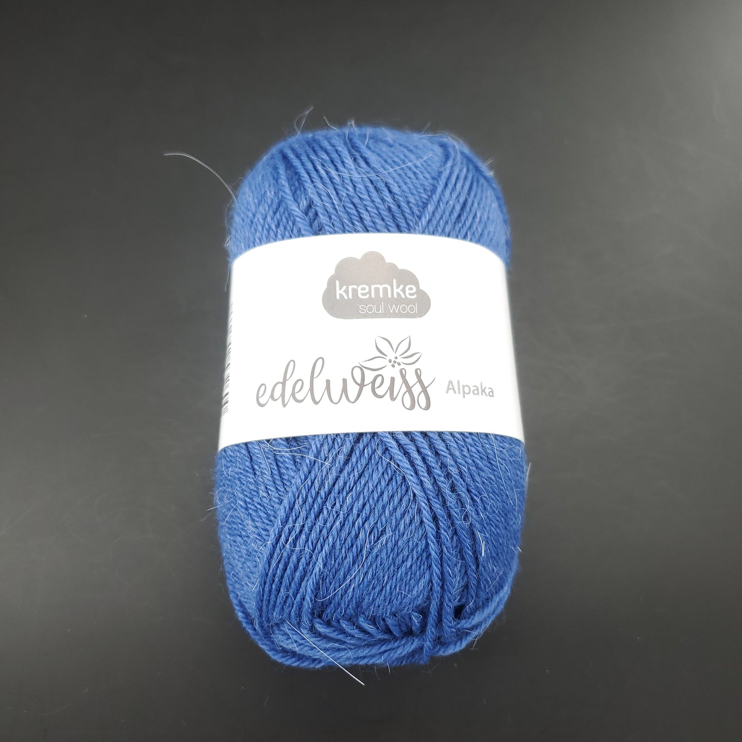 pelote de laine à chaussettes edelweiss alpaka 4ply de marque kremke de couleur 040 pour tricot et crochet sur fond noir