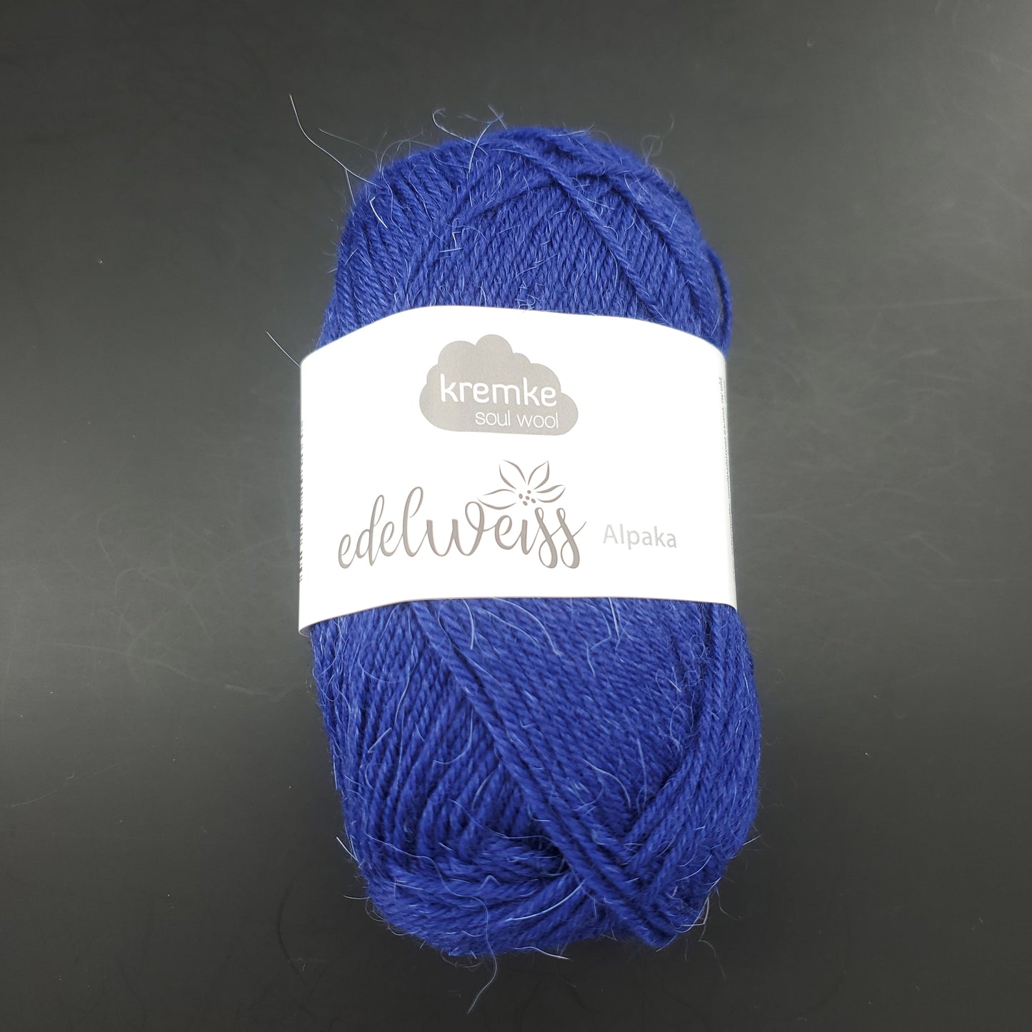 pelote de laine à chaussettes edelweiss alpaka 4ply de marque kremke de couleur 042 pour tricot et crochet sur fond noir