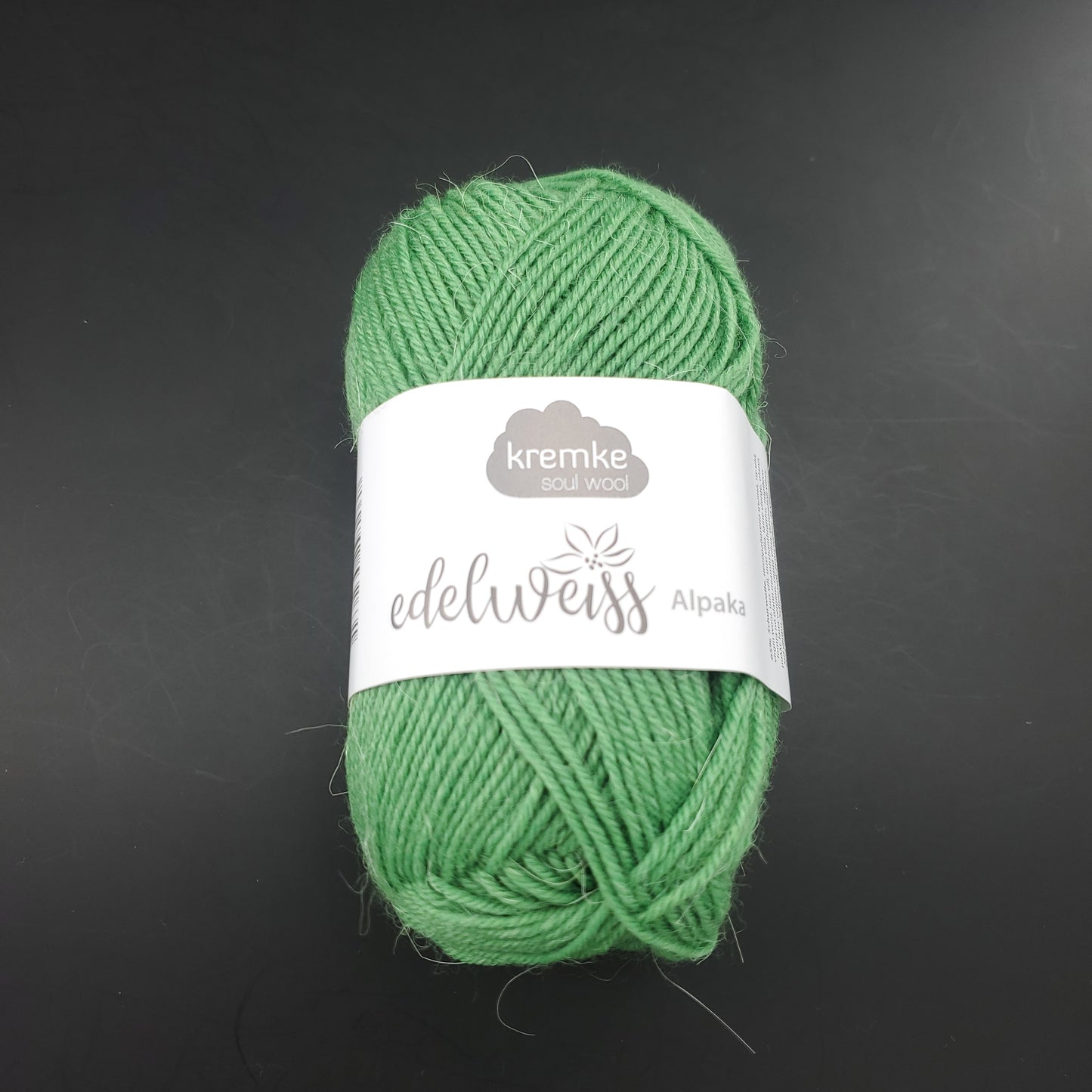 pelote de laine à chaussettes edelweiss alpaka 4ply de marque kremke de couleur 043 pour tricot et crochet sur fond noir