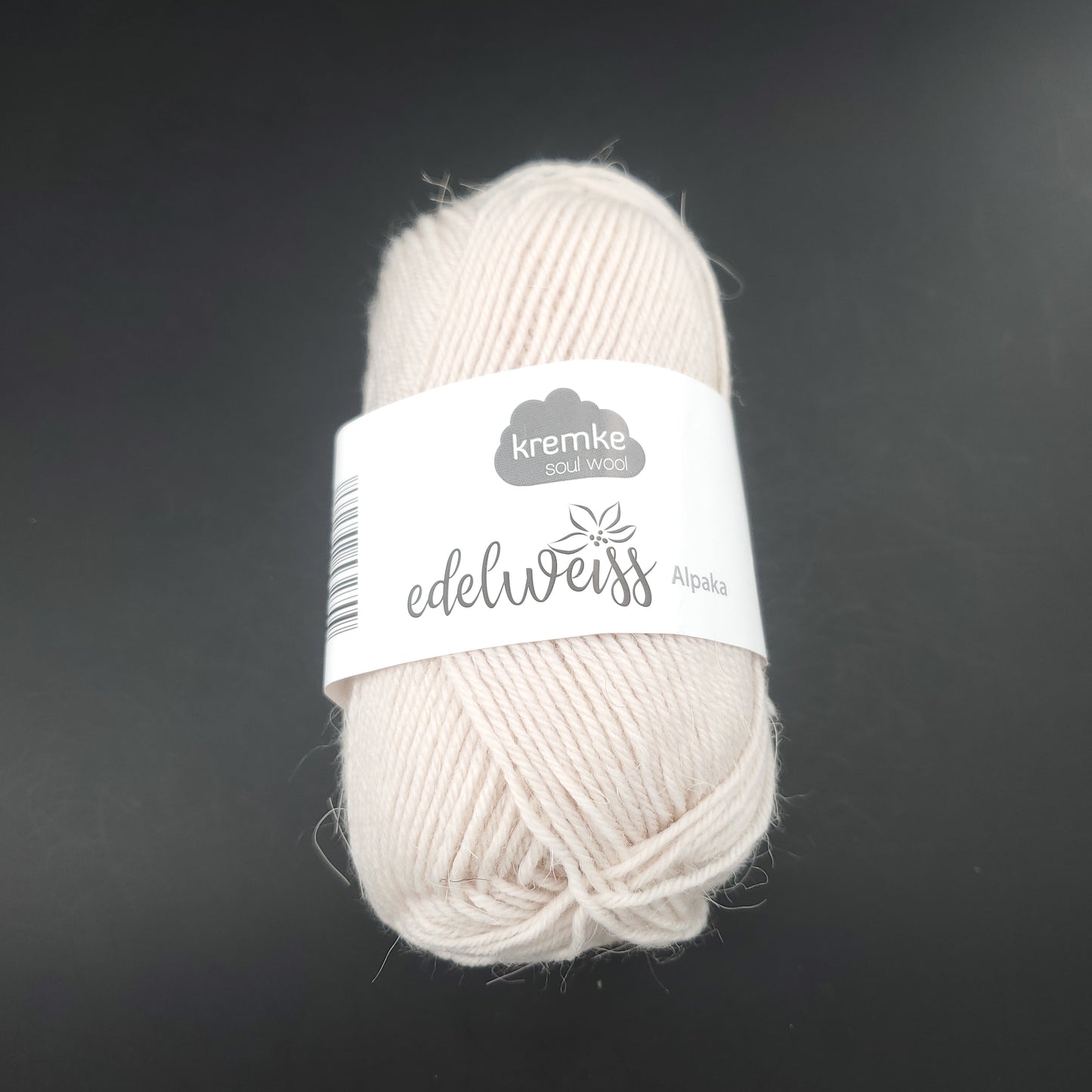 pelote de laine à chaussettes edelweiss alpaka 4ply de marque kremke de couleur 050 pour tricot et crochet sur fond noir
