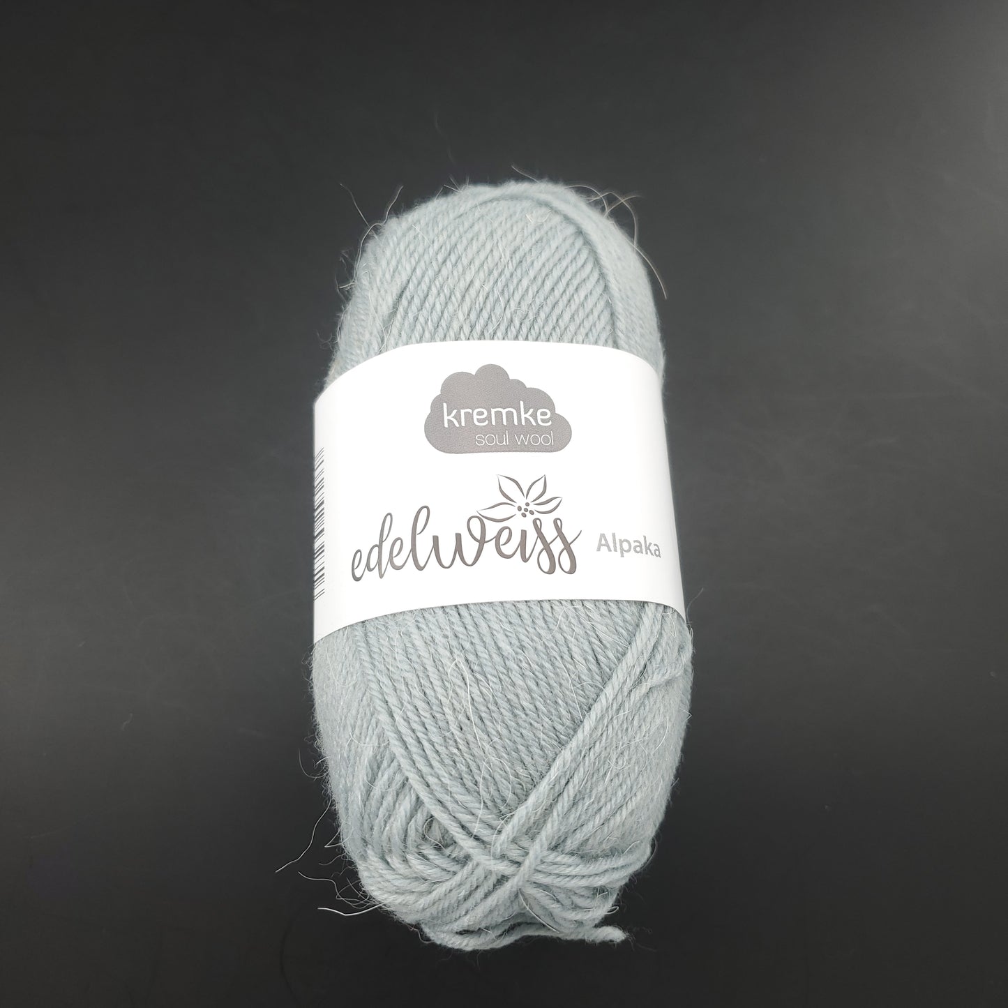 pelote de laine à chaussettes edelweiss alpaka 4ply de marque kremke de couleur 051 pour tricot et crochet sur fond noir