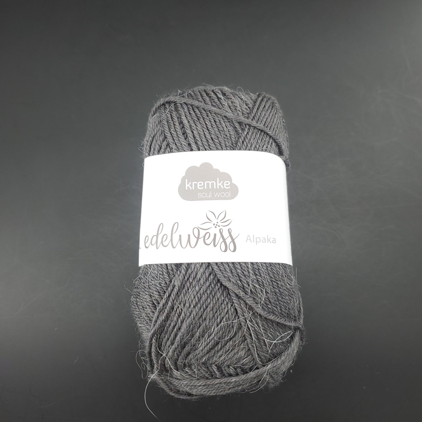 pelote de laine à chaussettes edelweiss alpaka 4ply de marque kremke de couleur 054 pour tricot et crochet sur fond noir
