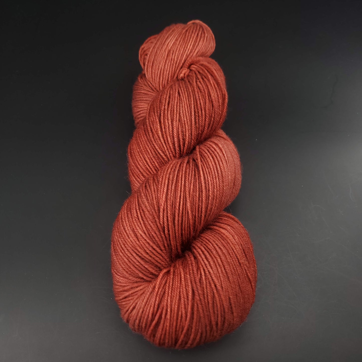 echeveau de laine merinos lazy lion unie de marque kremke de couleur rusty red pour tricot et crochet, sur fond noir