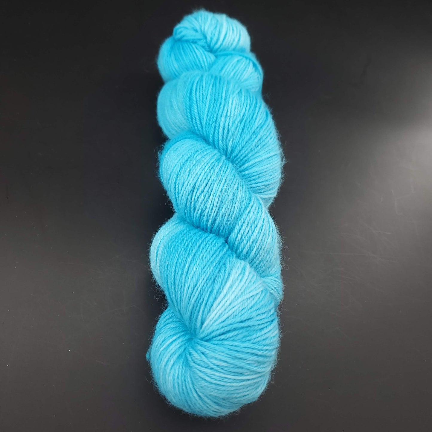 echeveau de laine merinos lazy lion unie de marque kremke de couleur turquoise pour tricot et crochet, sur fond noir