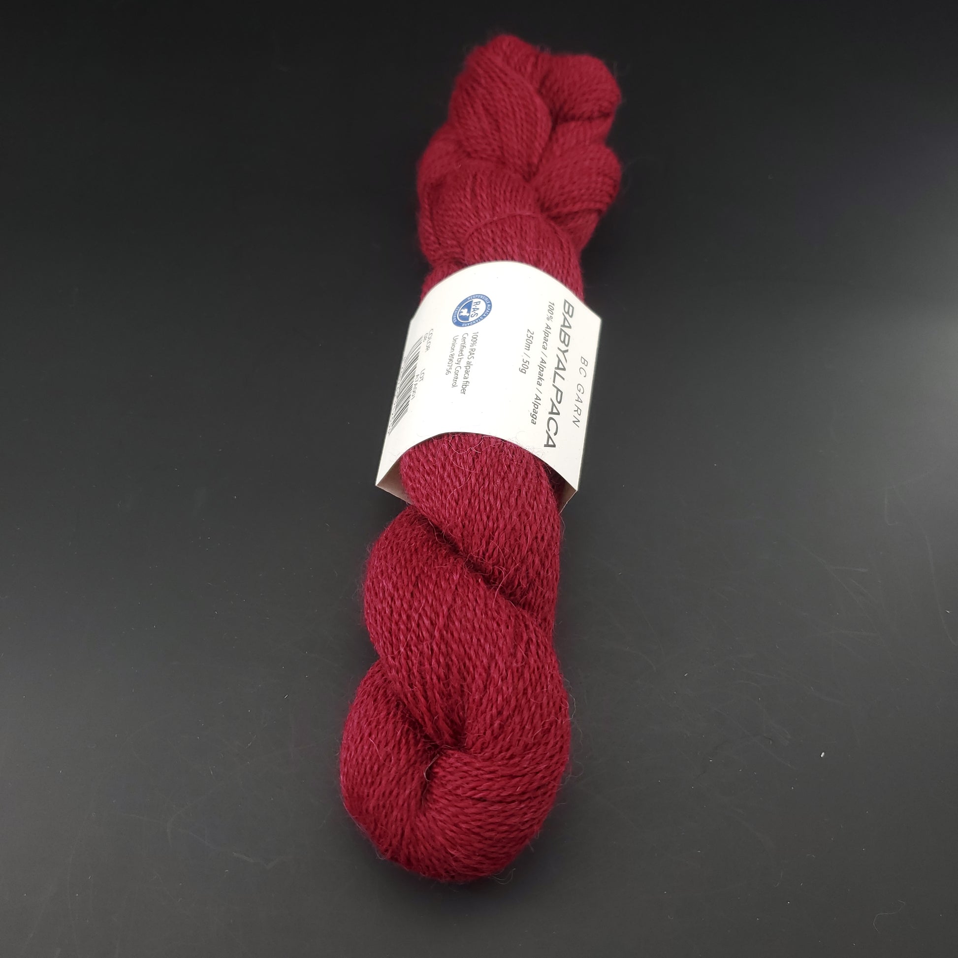 Echeveau de laine Baby Alpaca de BC Garn de couleur 08 wine sur fond noir.